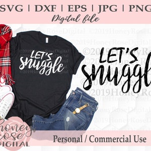 Puede incluir: Una camiseta negra con el texto "Let's snuggle" en letras blancas. La camiseta está colocada sobre una superficie blanca con una bufanda de cuadros rojos, un par de zapatillas blancas y unos vaqueros azules. El texto "Honey Rose Digital" es visible en el fondo.