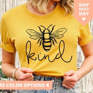 May include: A yellow t-shirt with a black bee graphic and the word "kind" in a cursive font.
