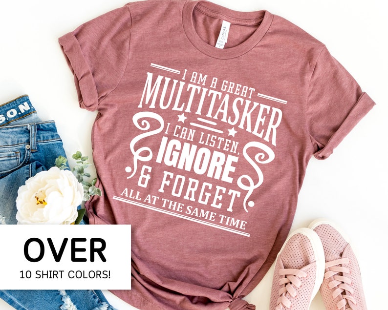 May include: A mauve t-shirt with white text that reads "I am a great multitasker. I can listen, ignore & forget all at the same time".