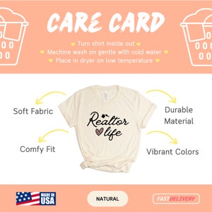 May include: A beige t-shirt with the text "Realtor life" in black with a pink heart and a house graphic. The shirt is shown folded on a white background with yellow arrows pointing to the words "Soft Fabric", "Comfy Fit", "Durable Material", and "Vibrant Colors". The words "Made in USA", "Natural", and "Fast Delivery" are also shown at the bottom of the image.