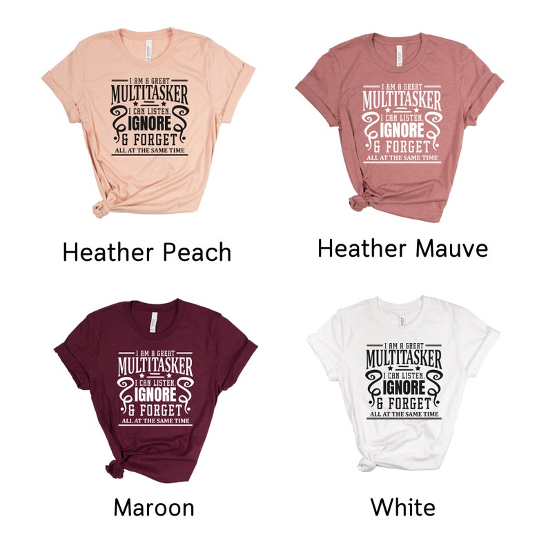 May include: Four t-shirts in different colors: heather peach, heather mauve, maroon, and white. Each shirt features a black graphic print that reads "I am a great multitasker I can listen ignore & forget all at the same time".