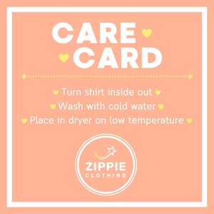 May include: A peach-colored care card with white text that reads "CARE CARD". The card has instructions for caring for a shirt: "Turn shirt inside out", "Wash with cold water", and "Place in dryer on low temperature". The card also has a yellow star logo with the text "ZIPPIE CLOTHING".