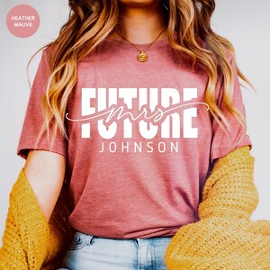 May include: A heather mauve t-shirt with the text "Future Mrs. JOHNSON" in white.