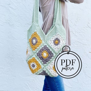 Puede incluir: Un bolso tote de crochet con un patrón geométrico de cuadrados en tonos de verde, blanco, marrón y amarillo. El bolso tiene una correa larga y está hecho con un punto de granny square. La imagen incluye el texto "PDF pattern".
