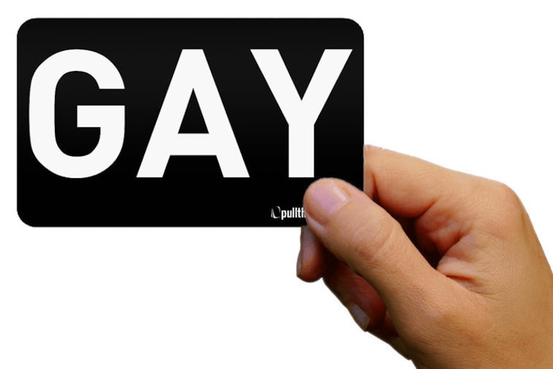 May include: A black card with the word "GAY" printed in white letters.