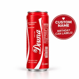 Op de afbeelding: Een rode aluminium drankblikje met een aangepast wit etiket met de naam Douna in cursief schrift, de tekst Have a wonderful celebration, We love you, Since 1990, From: Mon & Dad, Date: 18.12.2026 en een voedingswaardetabel met een inhoud van 330ml.
