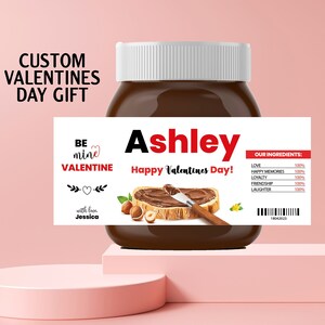 May include: A white jar of chocolate spread with a personalized label that says "Ashley Happy Valentines Day!"  The label also includes the text "Be mine Valentine" with a heart and "with love Jessica".
