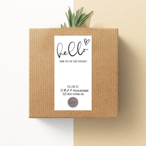 May include: A white thank you card with black text that says "hello" and a small heart. The text below says "Thank you for your purchase!" and includes social media and contact information.