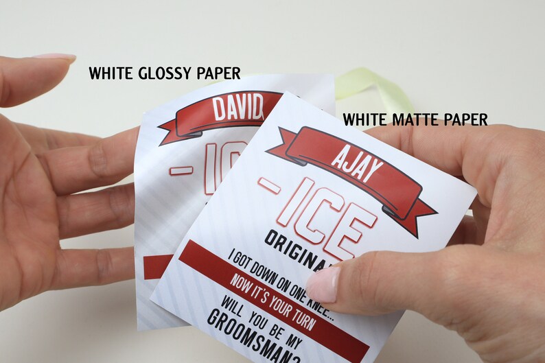May include: Two rectangular paper tags with red and white graphics. One tag labeled WHITE GLOSSY PAPER features the name DAVID, while the other labeled WHITE MATTE PAPER features the name AJAY. Both tags display the text ICE ORIGINAL and WILL YOU BE MY GROOMSMAN?
