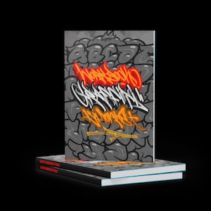 May include: A stack of notebooks with graffiti art on the covers. The top notebook features a gray background with a graffiti design in red, white, and orange. The text on the cover reads "GRAFFITI WORKBOOK BY TONELI".