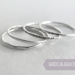 May include: Three silver rings with hammered textures. The rings are stacked on top of each other.  Mix & Match.
