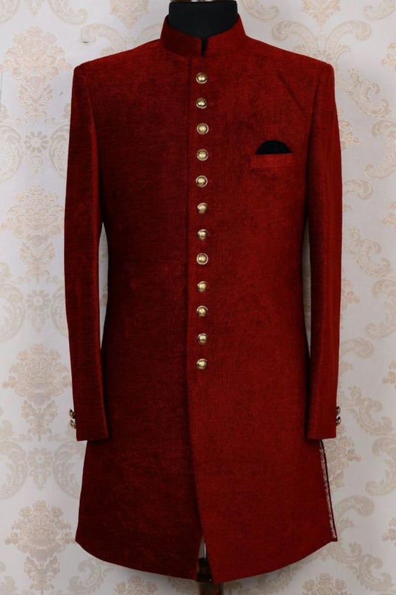 May include: A long, burgundy-colored jacket with a mandarin collar and gold buttons. The jacket has a single pocket on the left side of the chest.