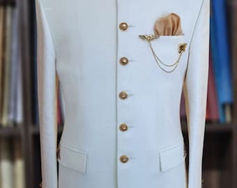 May include: A white men's suit jacket with a mandarin collar and gold buttons. The collar is decorated with gold embroidery. A gold chain and a gold pin are attached to the pocket square.