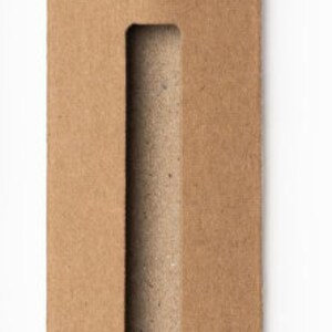 May include: A brown cardboard tube with a rectangular opening cut out of the side. The tube is designed to hold and protect a long, thin object.