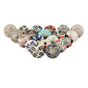 May include: A collection of 16 ceramic drawer knobs featuring a variety of floral patterns in shades of blue, red, green, and white. The knobs have a white base and a silver metal accent.