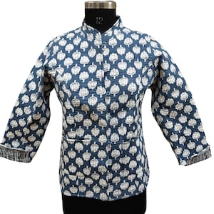 Peut inclure: Une veste matelassée bleue avec un imprimé floral blanc et un col mandarin. La veste a une fermeture boutonnée et deux poches.