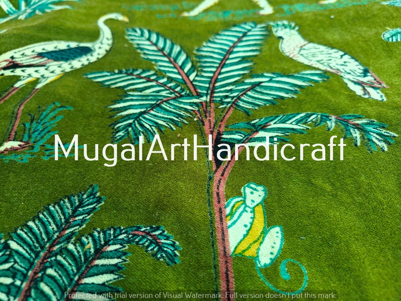 May include: Green fabric with a white and blue floral pattern. The pattern includes palm trees, birds, and other floral designs. The fabric has the text "MugalArtHandicraft" printed on it.