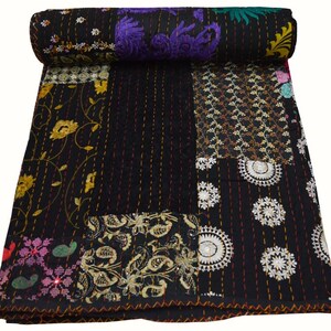 May include: Black kantha quilt with a patchwork design featuring floral and geometric patterns in gold, purple, and pink embroidery. The quilt is made of cotton and is hand-stitched.