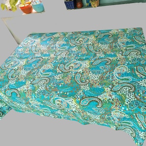 Peut inclure: Une courtepointe kantha bleu sarcelle avec un motif paisley. La courtepointe est en coton et a un design cousu à la main.