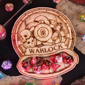 Puede incluir: Una bandeja de dados de madera con un diseño de calavera y ojo. La bandeja está grabada con la palabra "WARLOCK". Hay varios dados de colores en la bandeja y sobre un fondo de pergamino.