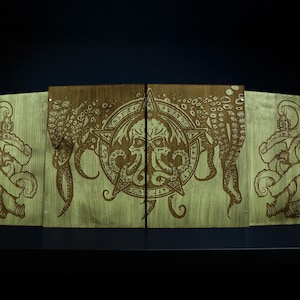 May include: Wooden panels with an engraved design featuring an octopus, a star, and nautical elements. The central panel has a detailed octopus design within a star, flanked by panels with octopus and banner motifs. The panels have a green and brown colour scheme.