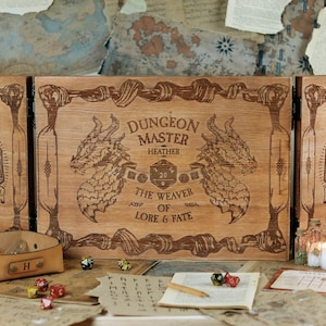 May include: A wooden box with a hinged lid, decorated with a dragon design and the text "Dungeon Master Heather The Weaver of Lore & Fate". The box is open and there are dice and other game pieces inside.