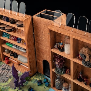 May include: Wooden tabletop gaming organizer with multiple compartments and shelves. The organizer is filled with dice, miniatures, and other gaming accessories. Clear acrylic dividers are on top. A map and dragon illustration are visible.