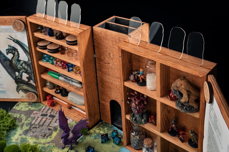 May include: Wooden tabletop gaming organizer with multiple compartments and shelves. The organizer is filled with dice, miniatures, and other gaming accessories. Clear acrylic dividers are on top. A map and dragon illustration are visible.