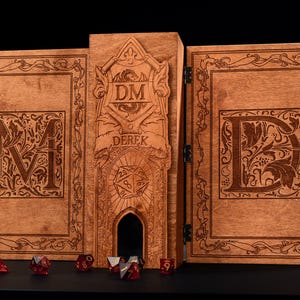 May include: A wooden DM screen with intricate carvings and the name "DEREK" engraved. The screen features the letters "M" and "D" on the side panels, with a central panel displaying "DM" and a dice tower. Several red dice are placed in front.