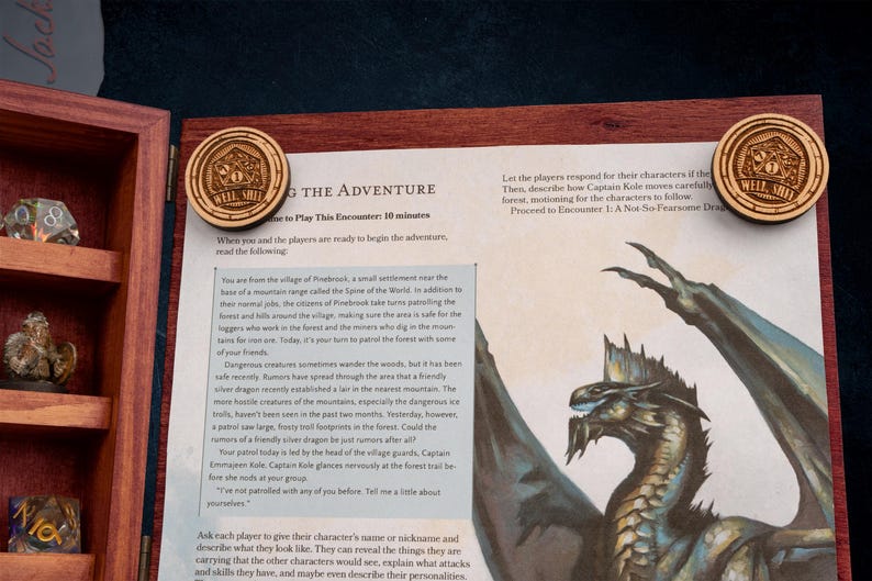 May include: Wooden game pieces with the text "WELL SHIT" and a dice icon are placed on a game board with a dragon illustration. The game board is inside a wooden box with dice and figurines.