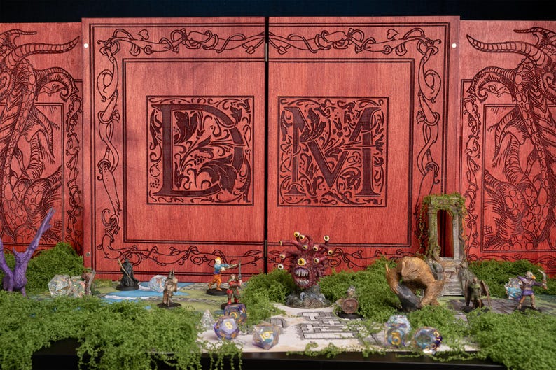 May include: A wooden game master screen with intricate carvings and a red-brown finish. The screen features large, ornate letters and a detailed border design. Miniature figures and terrain elements are arranged in front of the screen, creating a tabletop gaming scene.