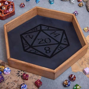 May include: A wooden hexagonal tray with a black felt lining and a large 20-sided die design. The tray is surrounded by various colored dice.