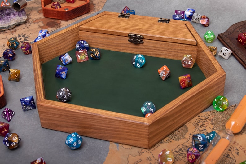 May include: A wooden hexagonal dice tray with a green felt lining. The tray has a hinged lid and is filled with colorful dice.
