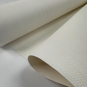 Puede incluir: Primer plano de un rollo de papel tapiz blanco texturizado. El papel tapiz tiene un patr&oacute;n tejido sutil.