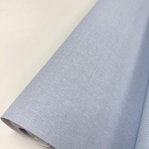 May include: A roll of light blue fabric with a textured surface.