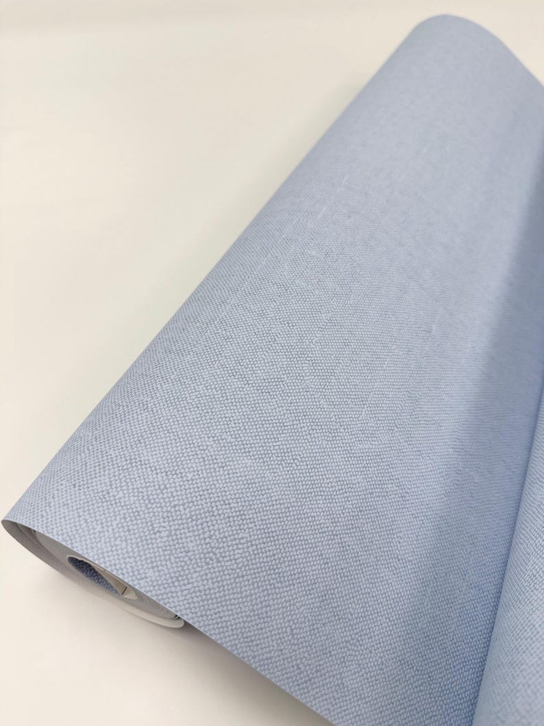 May include: A roll of light blue fabric with a textured surface.