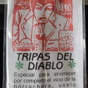 May include: A white packet with red and green illustrations. The packet has the text "LEGITIMO POLVO" at the top and "TRIPAS DEL DIABLO" in the centre. The text below reads "Especial para aborrecer por completo el vicio de la borrachera, uselo poniendo una pulgada de polvo en las comidas."