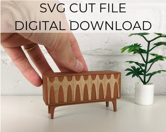 May include: A 1:16 scale Mid-Century Credenza SVG cut file digital download. The credenza is brown with a geometric pattern on the front.