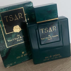 Könnte beinhalten: Dunkelgrüne Flasche TSAR de Van Cleef & Arpels Paris Eau de Toilette mit passender Schachtel. Die Flasche ist quadratisch mit einem dunkelgrünen Deckel. Auf der Schachtel und der Flasche befinden sich goldfarbene Schriftzüge. Enthält 125 ml Parfüm.