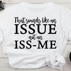 May include: White t-shirt with black text that reads "That sounds like an ISSUE not an ISS-ME".