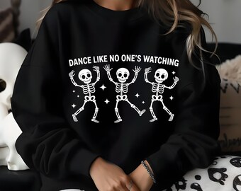 May include: Black sweatshirt featuring three dancing skeleton figures with the text "DANCE LIKE NO ONE'S WATCHING" in white. The skeletons are in a playful pose, with arms raised and legs spread.