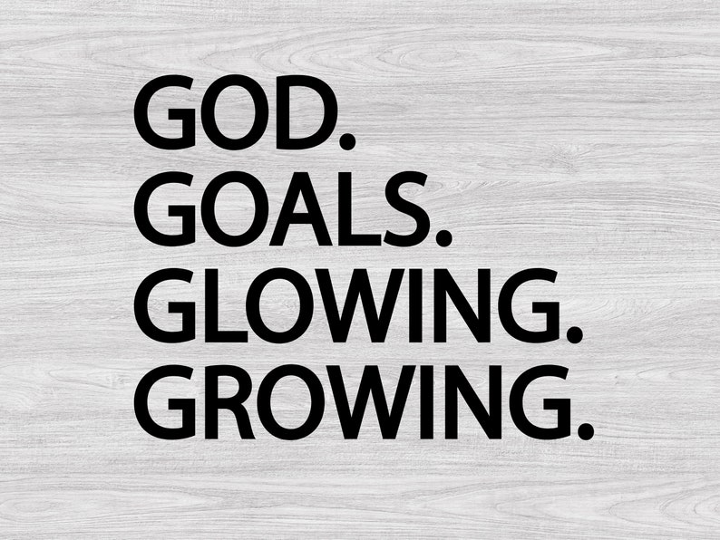 以下が含まれることがあります： 白い木製の背景に黒い文字で「GOD. GOALS. GLOWING. GROWING.」と書かれています