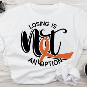 May include: White t-shirt with black text that reads "Losing is not an option" with an orange ribbon.