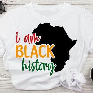 May include: White t-shirt with a black silhouette of the continent of Africa and the text "i am BLACK history" in red, orange, yellow, and green.