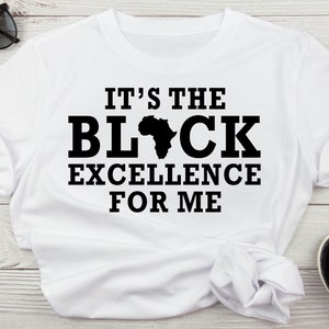May include: White t-shirt with black text that reads "It's the Black Excellence for Me" with a black silhouette of the continent of Africa.