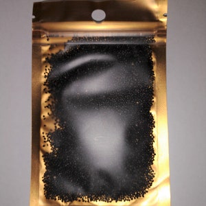 Peut inclure: Un sachet refermable dor&eacute; rempli de petites graines noires.