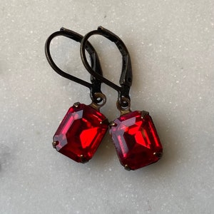 May include: A pair of earrings with red gemstone drops and antique bronze hooks.