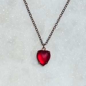 Collana con cuore luminoso glassato rosso sangue su catena di ottone antico.