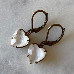 May include: A pair of antique gold heart-shaped earrings with clear iridescent glass stones.