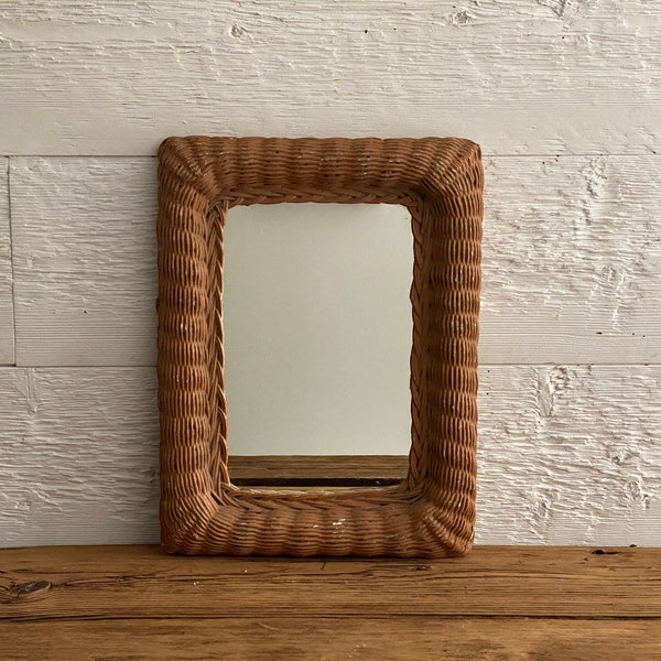 Vintage mirror in wicker frame  with old layers of blue and orange paint